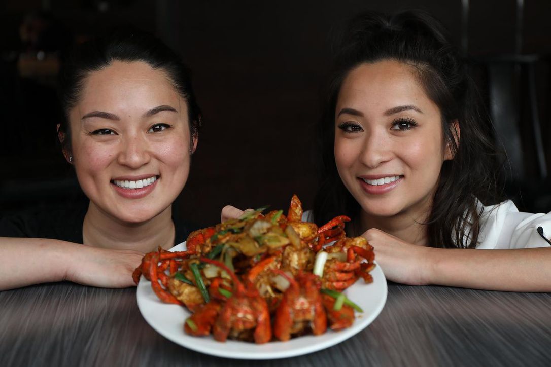 Two asian women with a plate of stir fried lobster